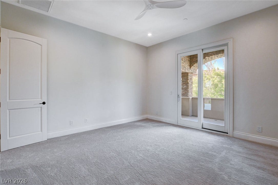84 Kittansett Loop, Henderson, NV 89052 Sliding glass doors open directly to a private balcony from this carpeted bedroom.