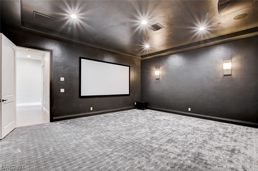 84 Kittansett Loop, Henderson, NV 89052 A dedicated home theater room showcases textured dark walls and soft overhead recessed lighting.