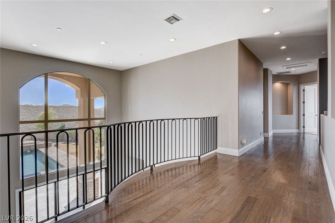 84 Kittansett Loop, Henderson, NV 89052 Rich hardwood floors and a curved iron railing highlight this open upper-level landing.