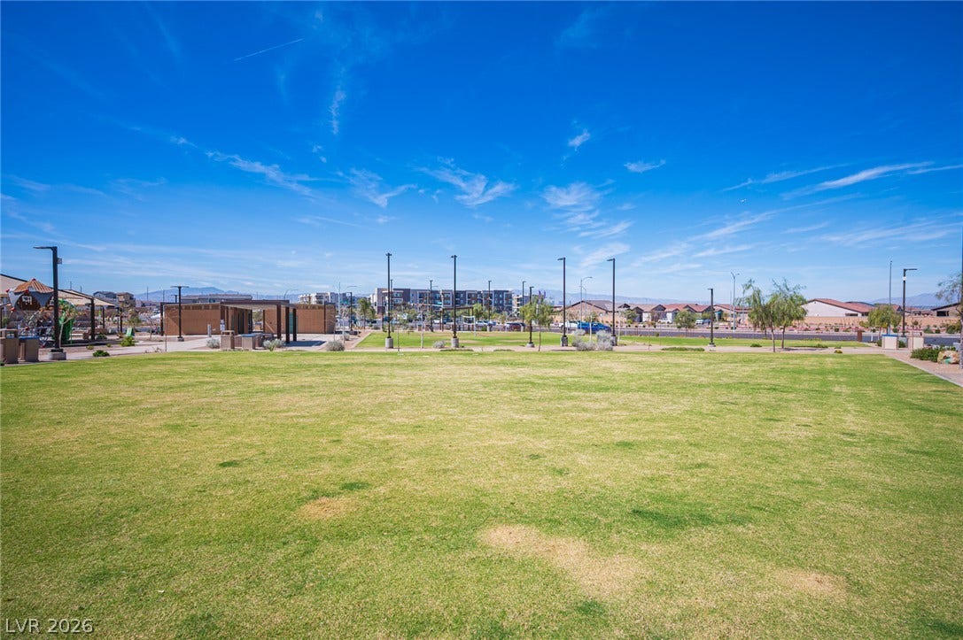 320 Della Pergola Place, Henderson, NV 89015 A spacious green park setting spreads out under a clear blue sky.