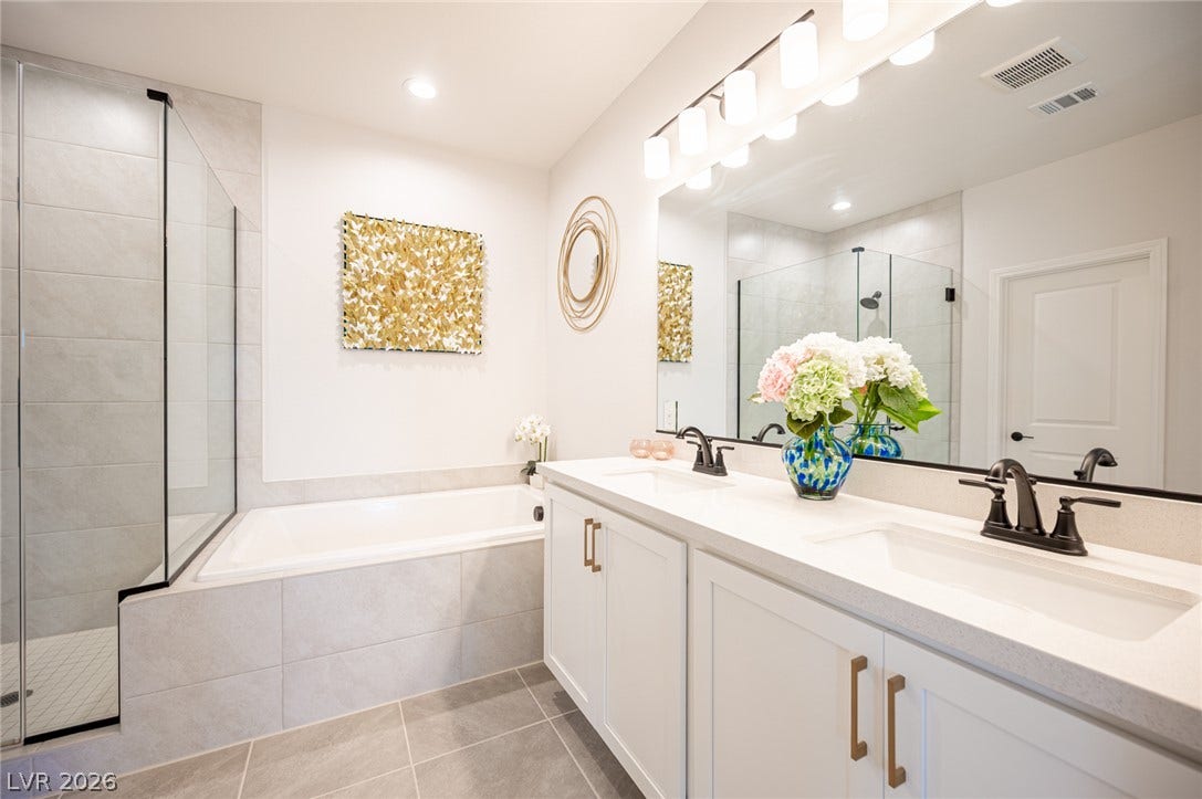 320 Della Pergola Place, Henderson, NV 89015 A spacious double vanity and a built-in soaking tub define this modern bathroom.