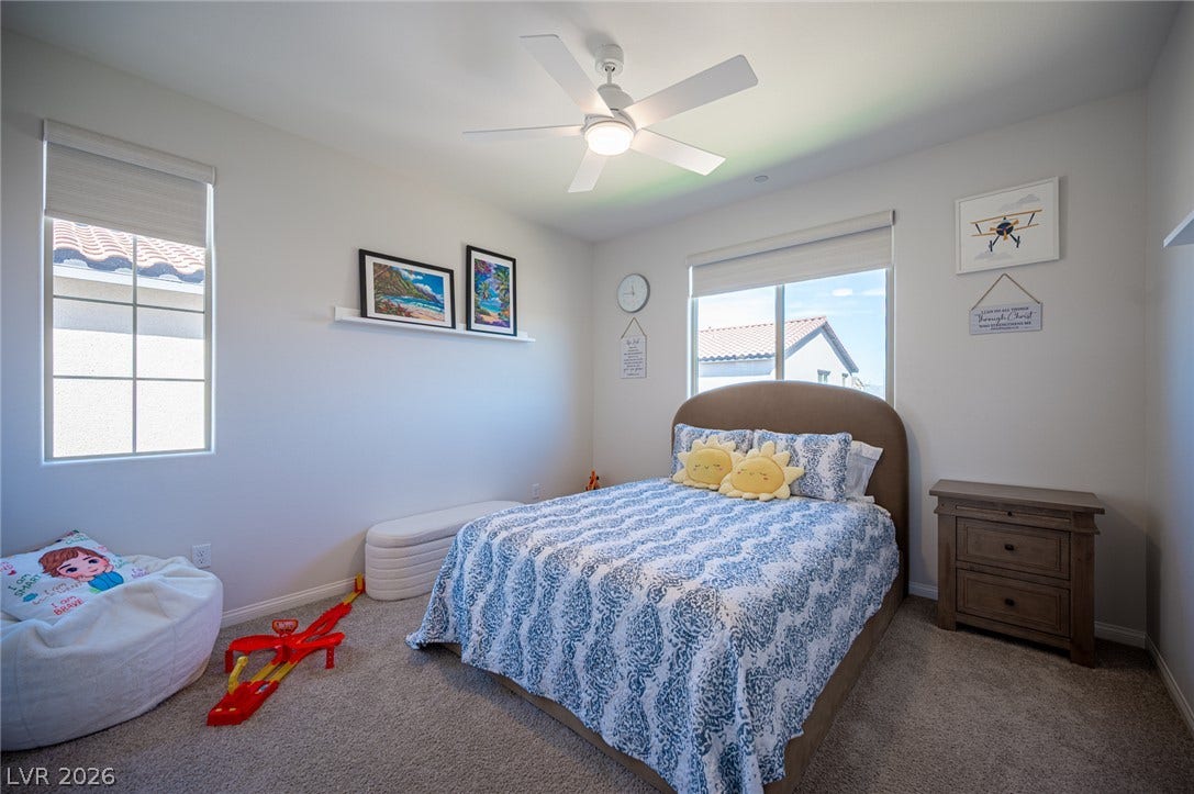 320 Della Pergola Place, Henderson, NV 89015 Natural light streams through multiple windows onto carpeted flooring in this comfortable secondary bedroom.