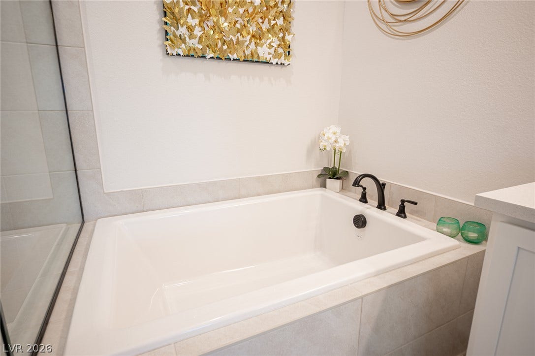 320 Della Pergola Place, Henderson, NV 89015 A deep soaking tub lined with clean tile offers a relaxing retreat.