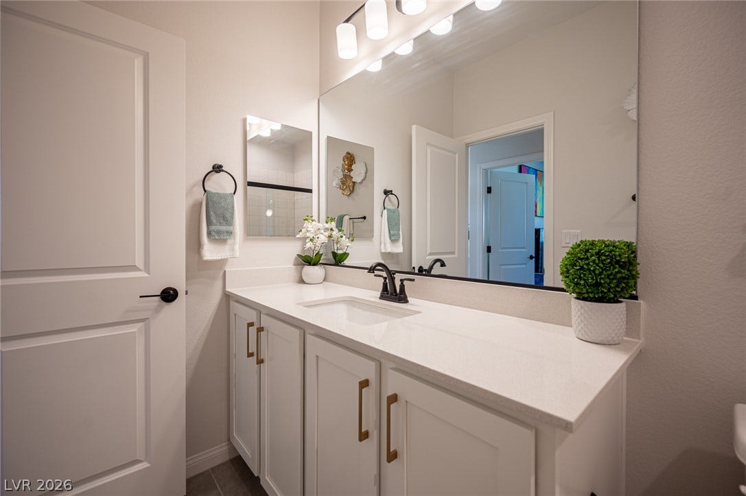 320 Della Pergola Place, Henderson, NV 89015 A spacious vanity with clean stone countertops and modern cabinetry updates this bathroom.