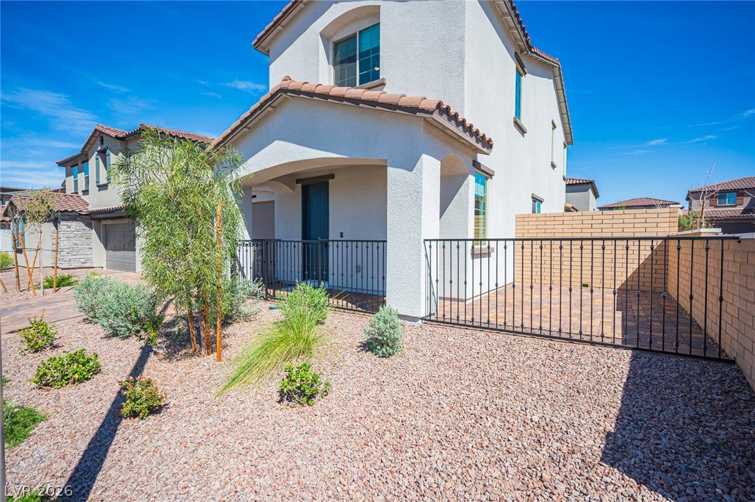 320 Della Pergola Place, Henderson, NV 89015 Desert landscaping and a gated entryway create curb appeal for this two-story stucco home.