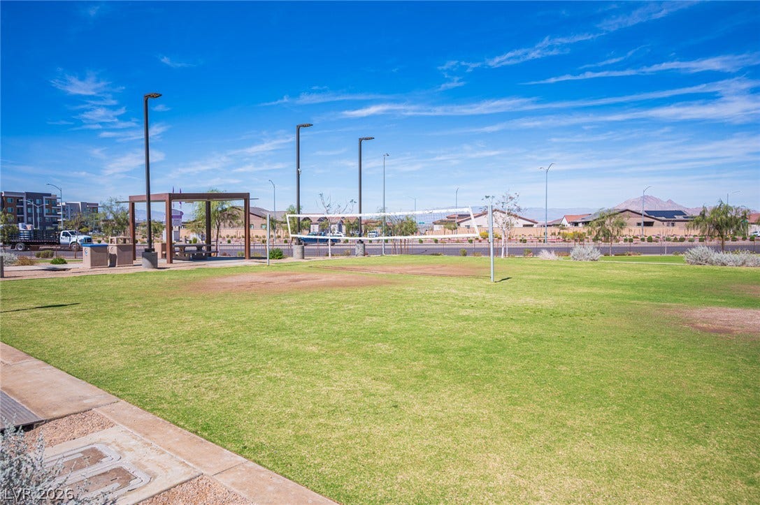 320 Della Pergola Place, Henderson, NV 89015 An outdoor community park features a green lawn, picnic shelter, and volleyball court under blue skies.