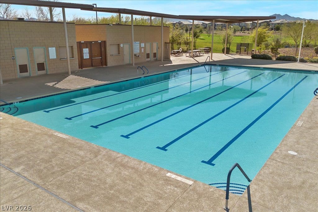 320 Della Pergola Place, Henderson, NV 89015 An expansive outdoor lap pool with concrete decking under a sunny sky.