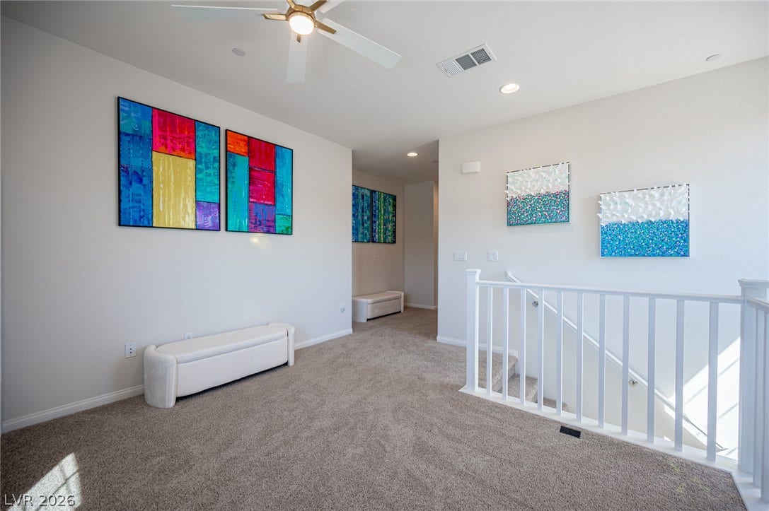 320 Della Pergola Place, Henderson, NV 89015 A spacious upper-level landing features soft carpeting and a wooden banister overlooking the staircase.