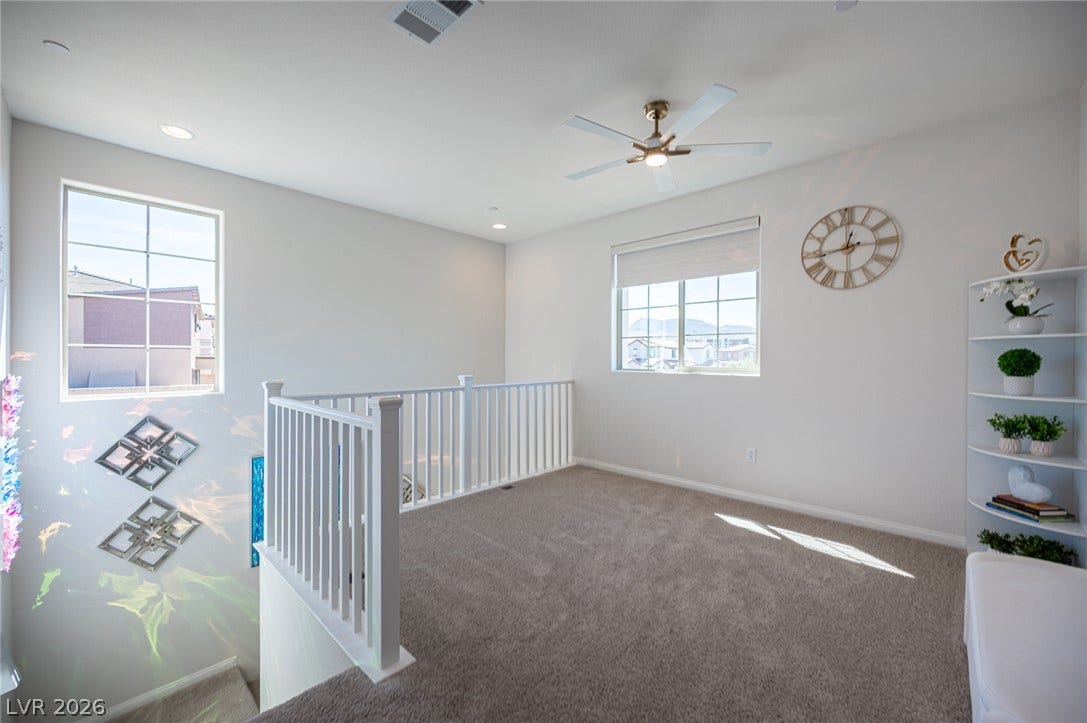320 Della Pergola Place, Henderson, NV 89015 Plentiful natural light fills this versatile upper loft featuring soft carpeting and clean white walls.