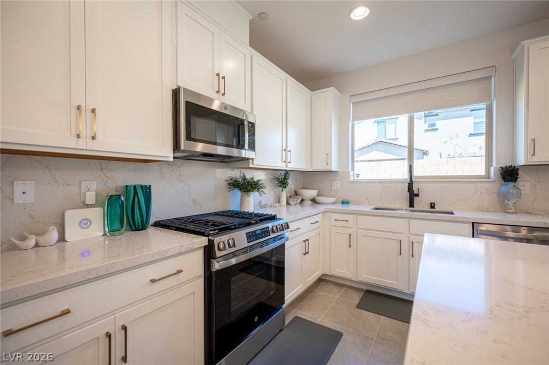 320 Della Pergola Place, Henderson, NV 89015 Gleaming stone countertops and crisp cabinetry anchor this bright, modern culinary space.