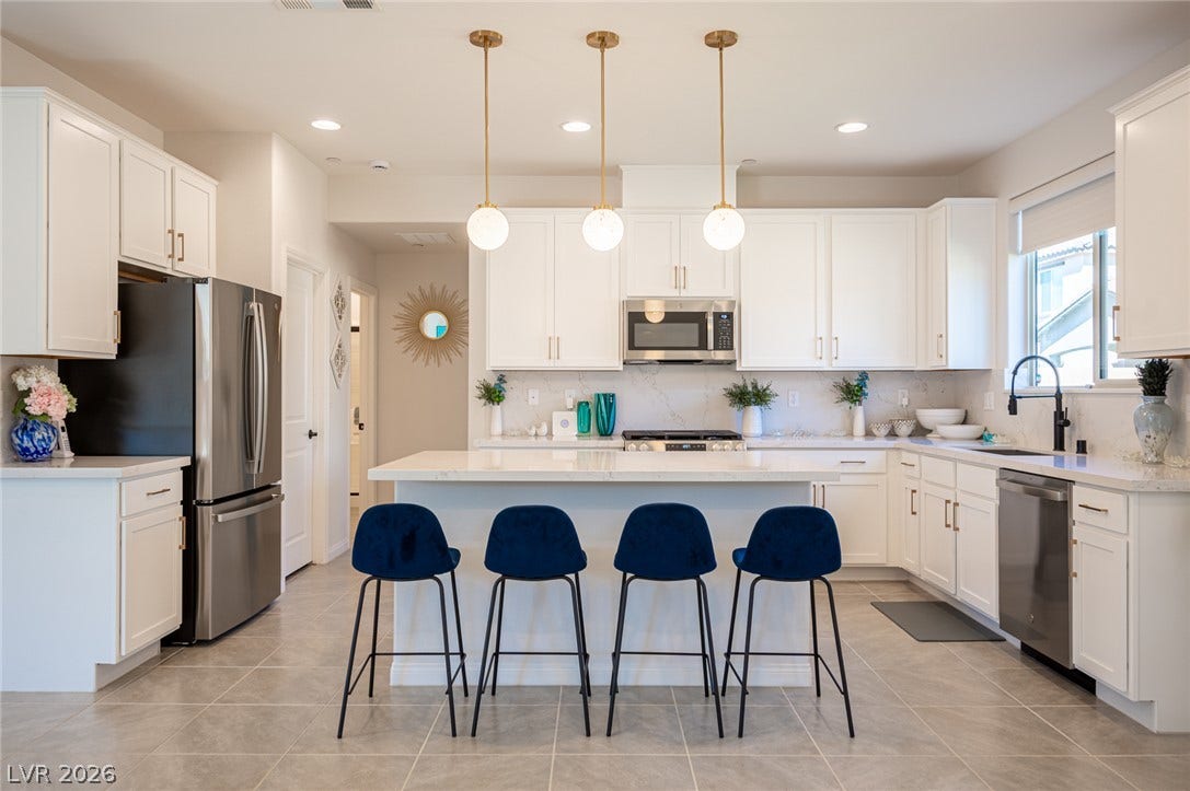 320 Della Pergola Place, Henderson, NV 89015 Crisp white cabinetry paired with stone countertops defines this modern culinary space.