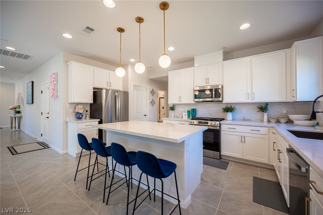 320 Della Pergola Place, Henderson, NV 89015 Gleaming stone countertops and a spacious central island anchor this contemporary kitchen design.