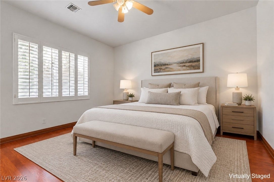 Bedroom downstairs. Warm hardwood flooring and plantation shutters define this serene bedroom space.