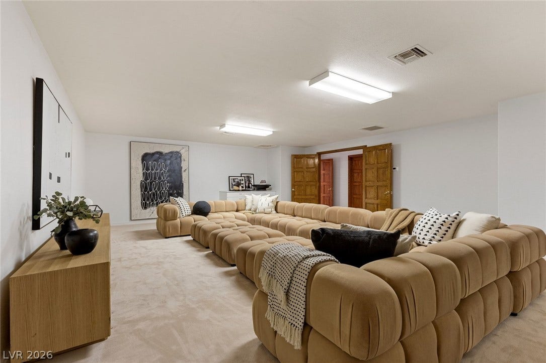 Double doors open into this versatile den, staged as a theater finished with wall-to-wall carpeting.