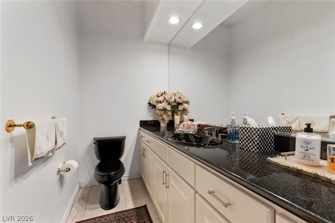 Gleaming stone countertops and recessed lighting elevate this modern bathroom space.