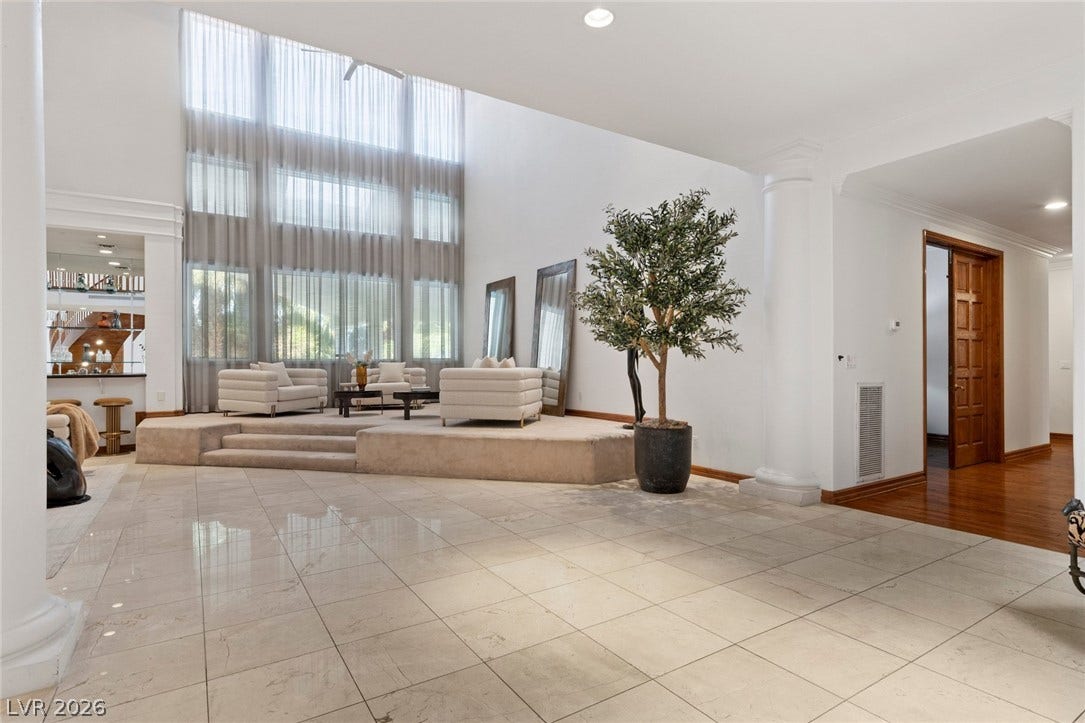 Polished tile flooring and soaring windows elevate this open architectural transition space.