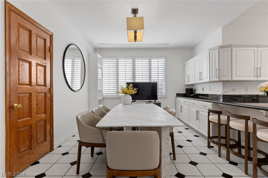 Geometric floor tiles and classic white cabinetry define this versatile dining and prep area.