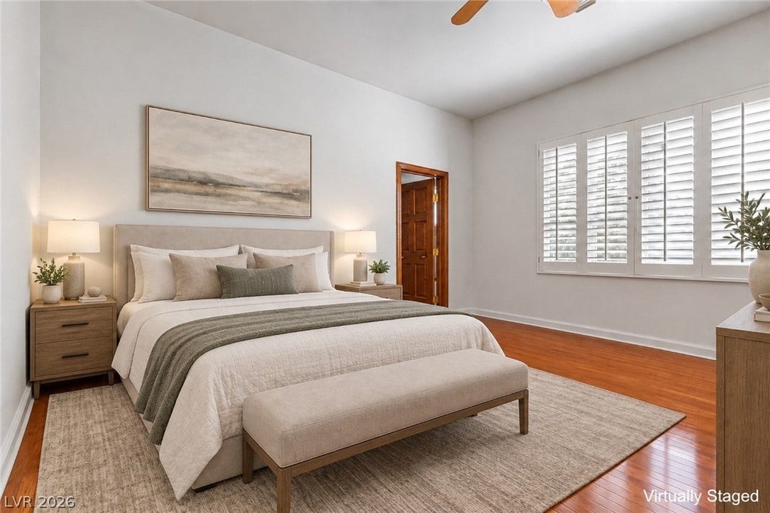 Bedroom downstairs. Gleaming hardwood floors and classic plantation shutters define this inviting bedroom space.