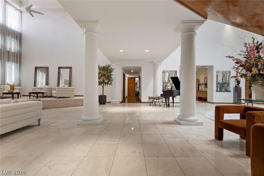 Gleaming tile floors and majestic columns frame a grand open foyer with towering ceilings.