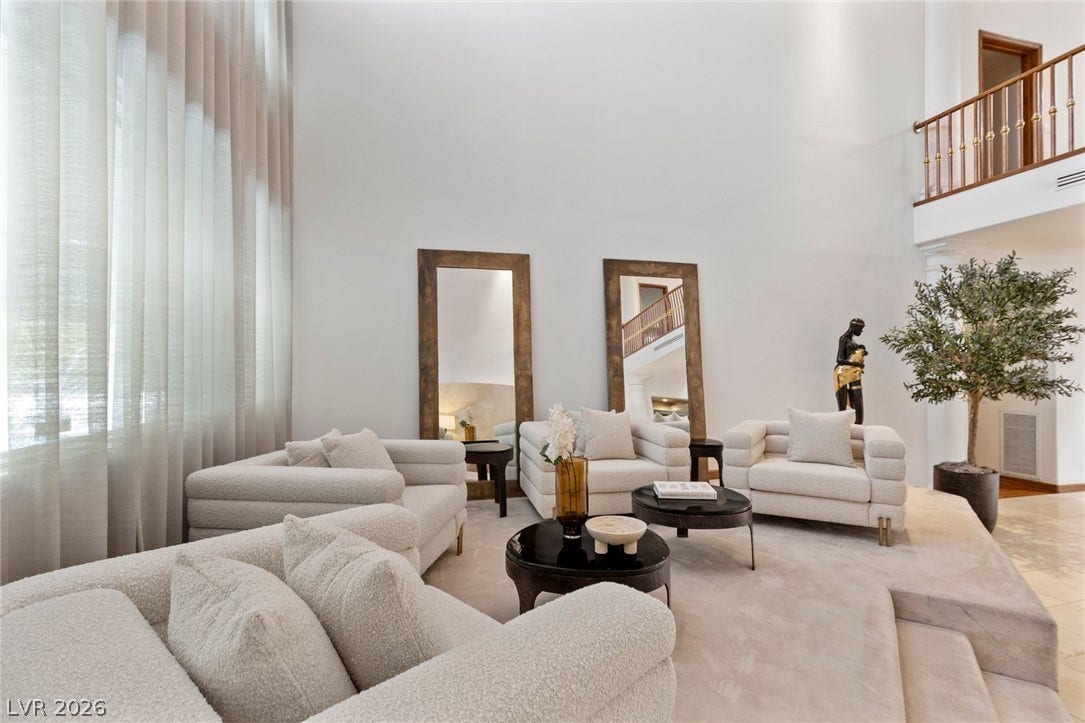 Towering ceilings and light-filled windows define this expansive multi-level living area.