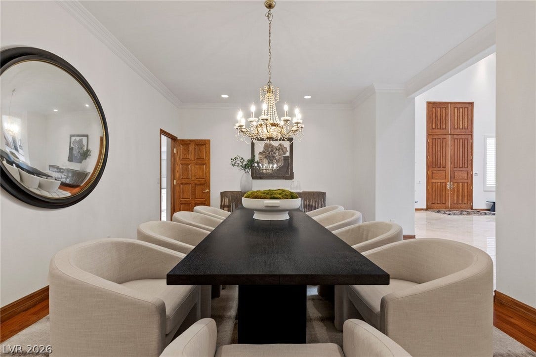Elegant crown molding complements warm wood baseboards in this refined formal dining room.