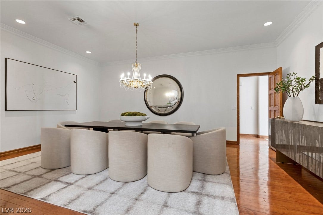 Polished hardwood floors and classic crown molding elevate this elegant dining space.
