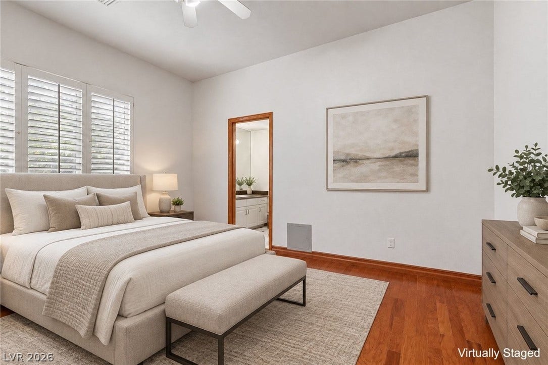 Bedroom downstairs. Rich hardwood flooring complements the high ceilings of this inviting bedroom retreat.