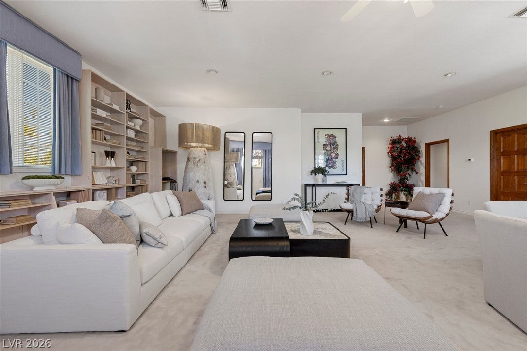 Built-in bookcases and soft wall-to-wall carpeting define this open living space.