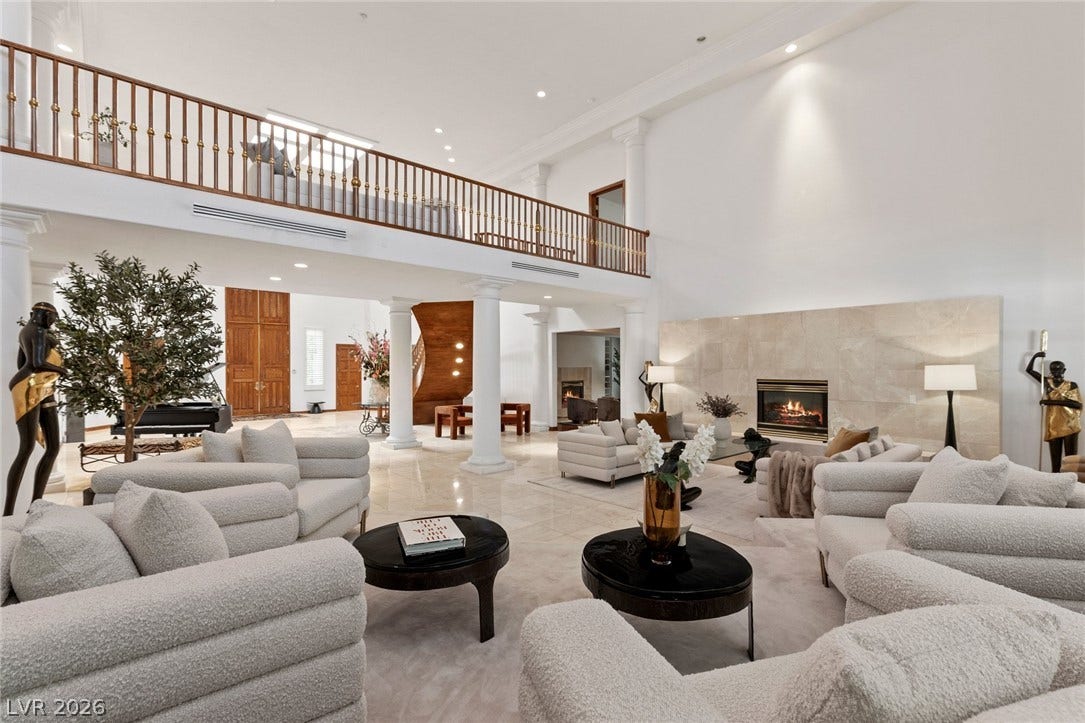 Soaring ceilings and a grand fireplace frame this cavernous, open-concept living space.