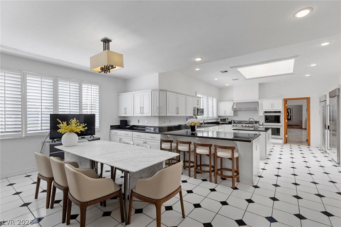 Gleaming tile floors anchor an expansive kitchen layout with built-in appliances and custom cabinetry.