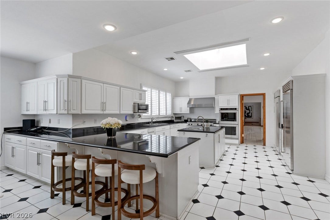 Polished stone countertops pair elegantly with patterned tile flooring in this sun-drenched culinary space.