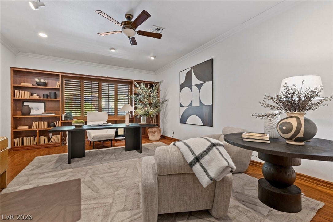 Gleaming hardwood floors and classic crown molding define this dedicated workspace with integrated shelving.