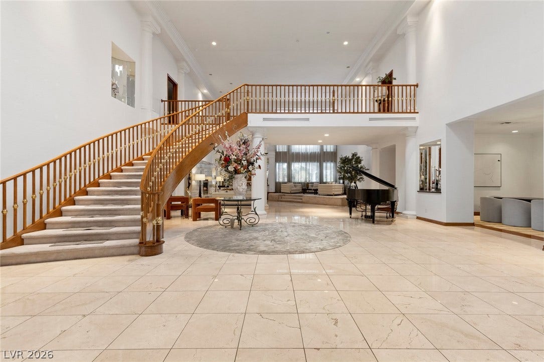 Gleaming tile floors and a sweeping curved staircase anchor this grand entrance foyer.