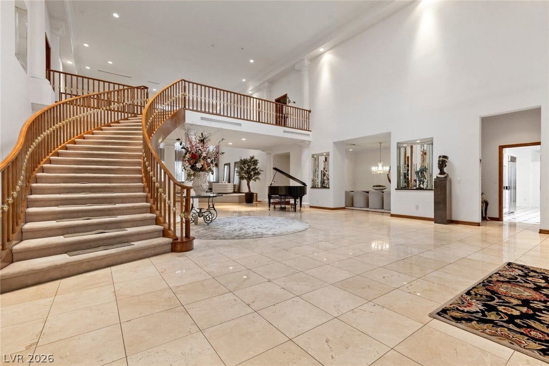 Polished tile flooring and a sweeping staircase anchor this grand entrance foyer.