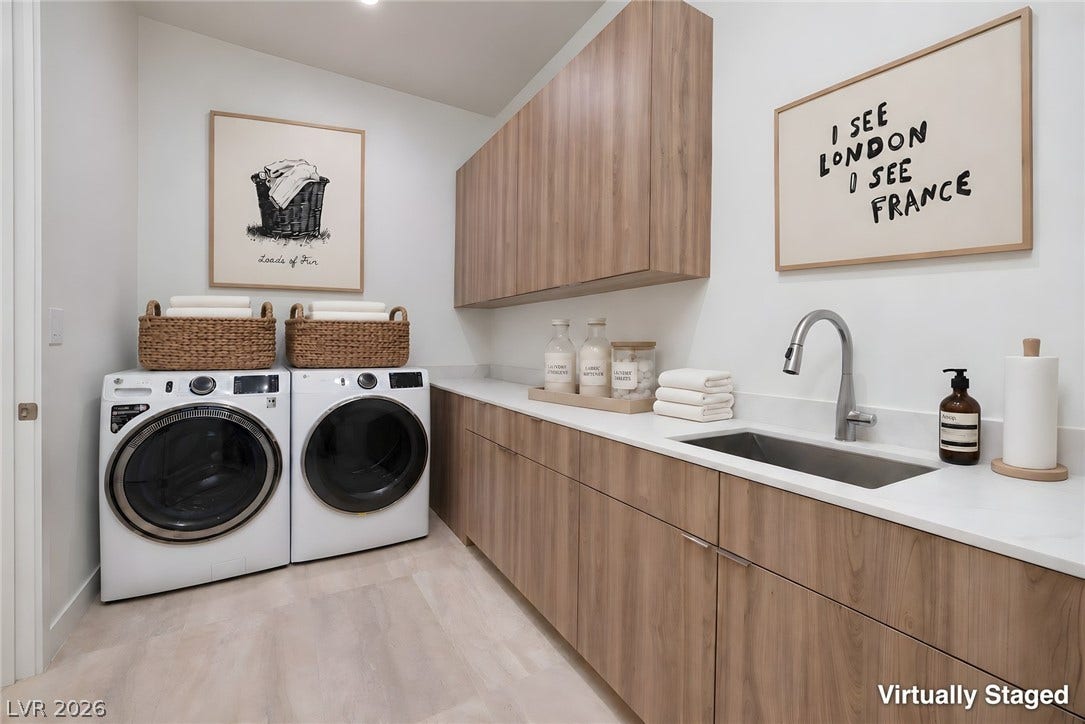 Streamlined cabinetry and a deep utility sink elevate this functional laundry space.