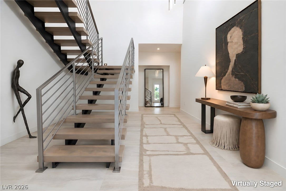 An open foyer showcases a striking modern staircase and light-filled architectural lines.