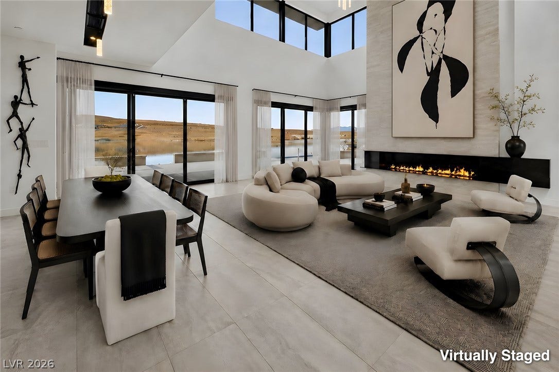 Towering ceilings and wall-to-wall sliding glass doors frame tranquil water views from the open living area.