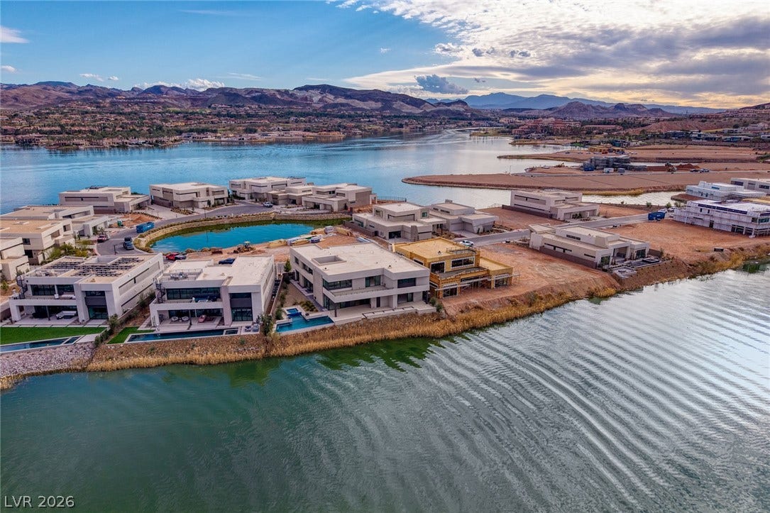 Striking modern architecture sits directly on the water with sweeping lake and mountain views.