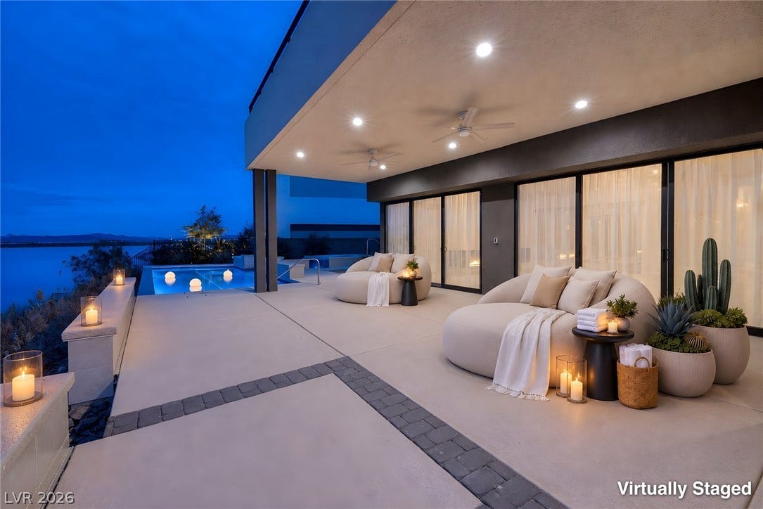 Smooth concrete floors flow seamlessly toward a sparkling pool and panoramic water views.