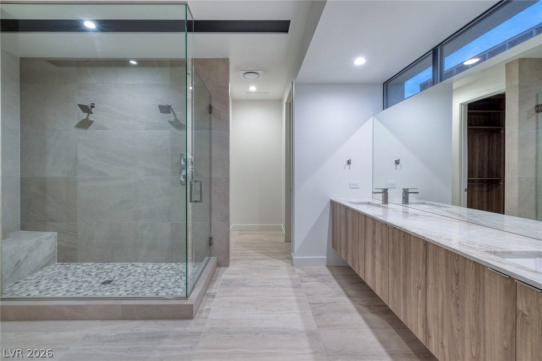 Clean lines and a spacious walk-in shower define this modern master bathroom retreat.