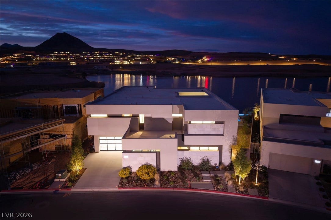 Bold geometric architecture commands attention along the serene waterside at twilight.
