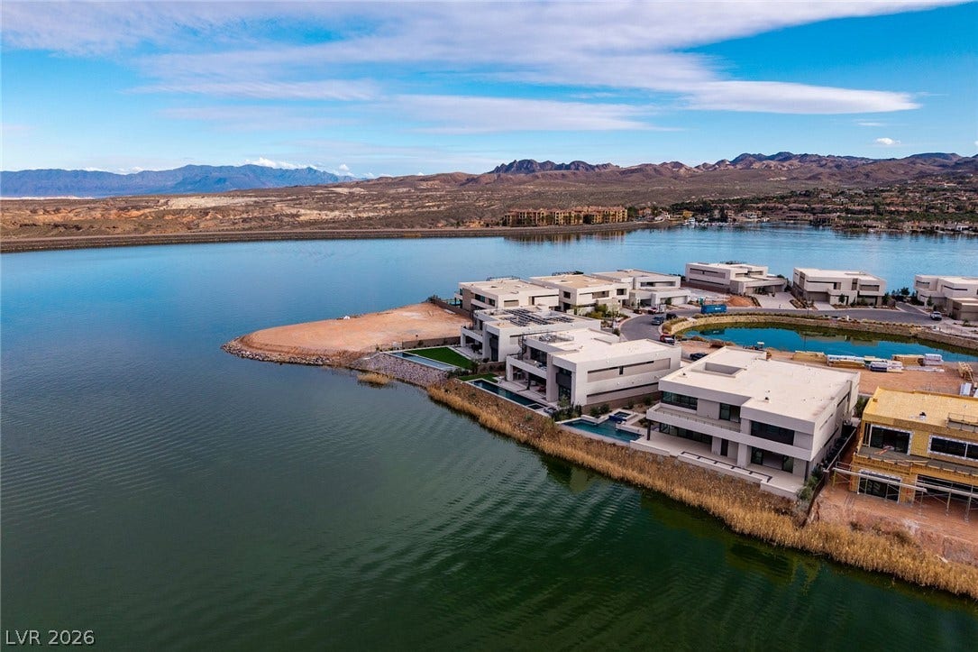 Modern lakeside architecture frames breathtaking water views against a dramatic desert mountain backdrop.
