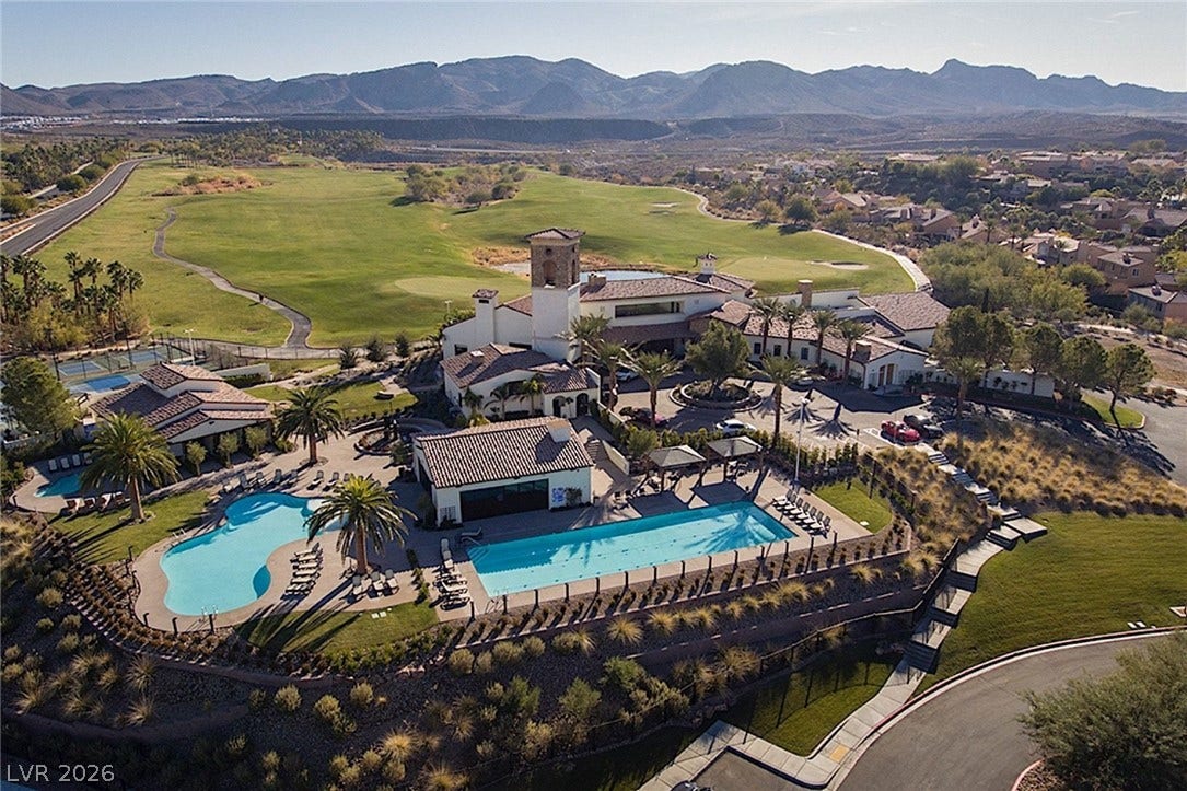 Dramatic mountain vistas frame this sprawling clubhouse complex featuring sparkling pools and green fairways.