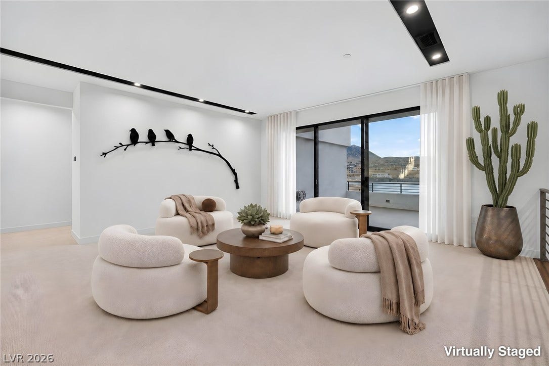Sliding glass doors frame picturesque mountain and neighborhood vistas from this carpeted living space.