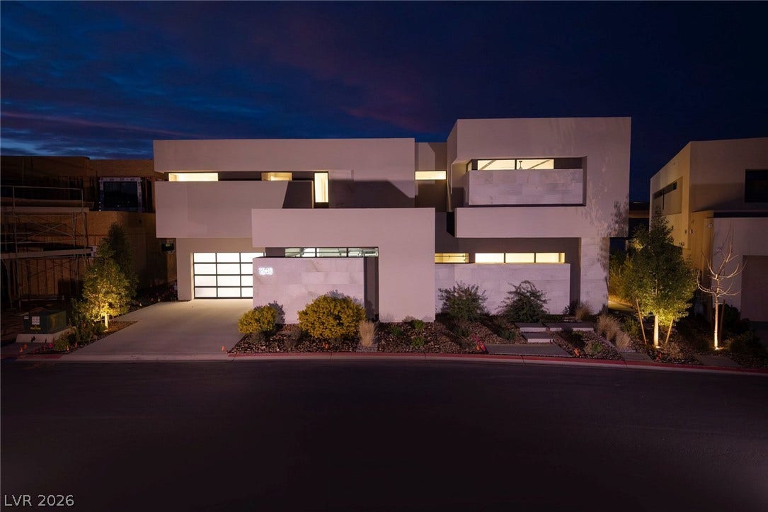 Striking contemporary architecture defines this luxury multi-level residence glowing against the twilight sky.