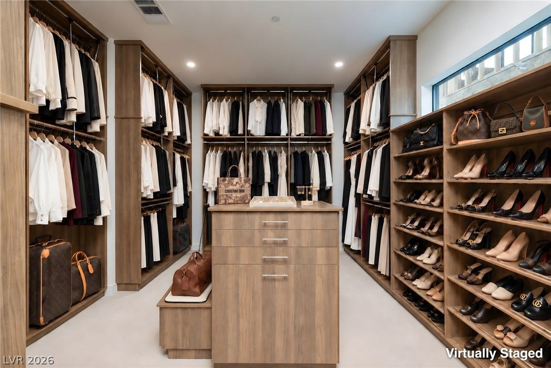 Floor-to-ceiling built-ins and a central storage island define this meticulously organized dressing room.