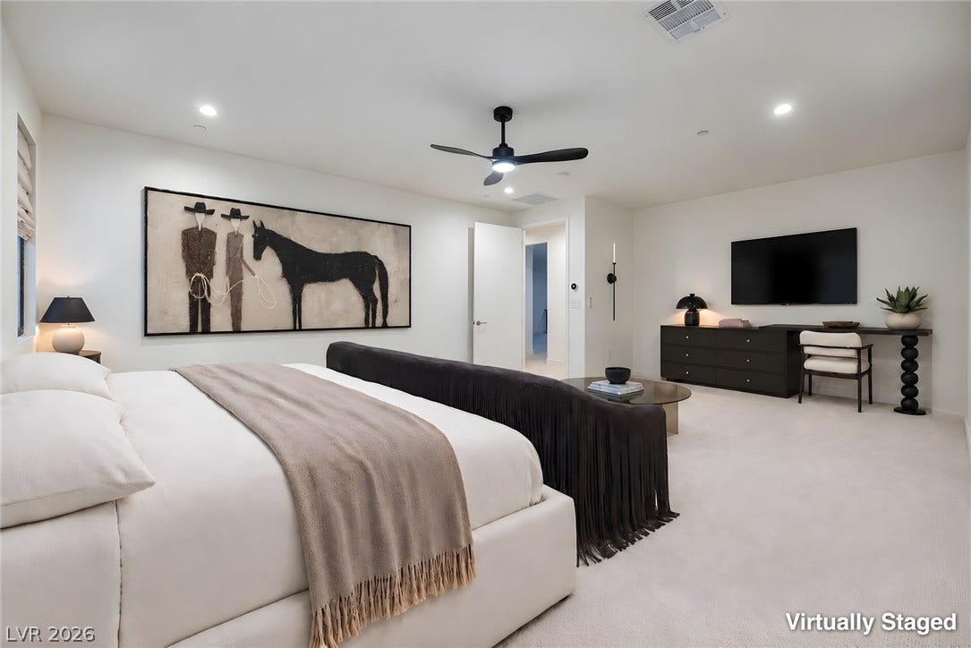 Recessed lighting illuminates this expansive bedroom featuring soft carpeting.