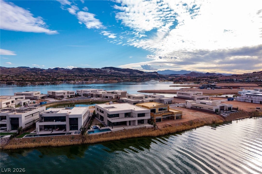 Striking contemporary architecture graces a prime peninsula surrounded by peaceful lake waters.
