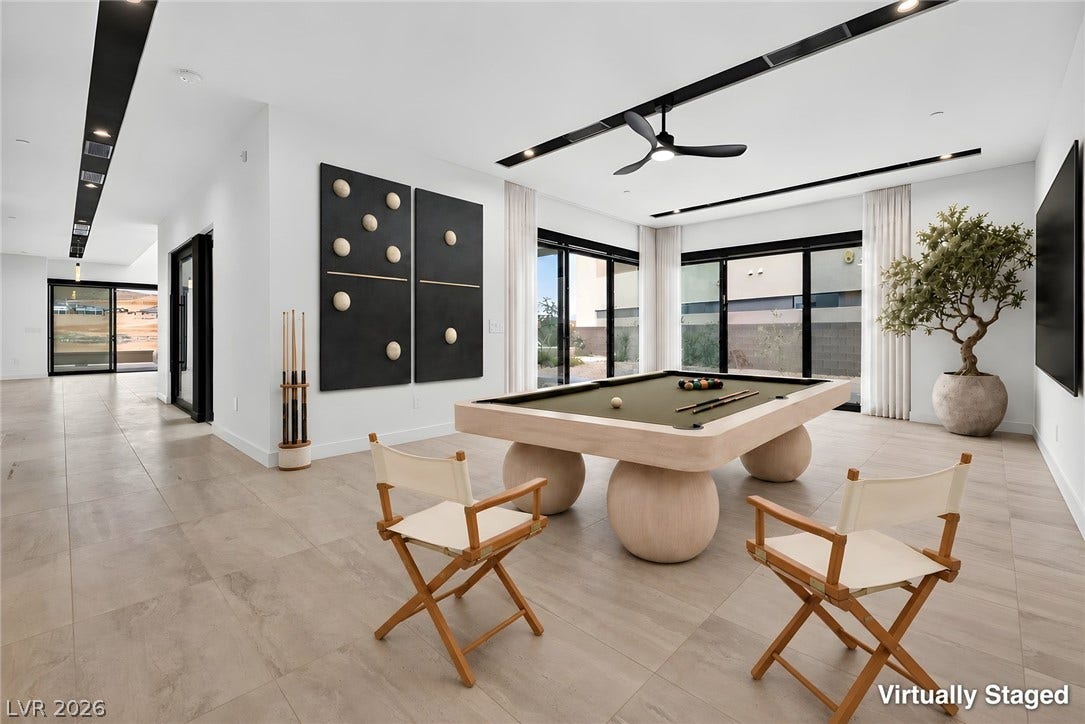 High ceilings and modern tile floors frame this contemporary game room with glass sliding doors.