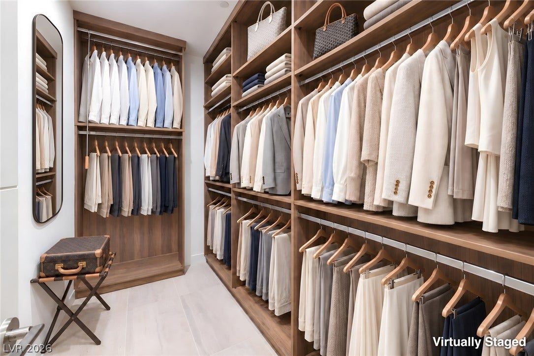 Floor-to-ceiling custom wood shelving maximizes storage space within this organized walk-in closet.